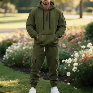 Outdoor shot of men's olive green fleece tracksuit featuring cargo pockets and half-zip hoodie