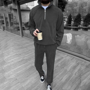 Detailed view of men's dark grey corduroy tracksuit with half-zip stand collar and trousers