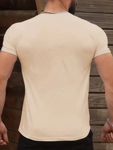 Close-up of beige casual sports T-shirt fabric showing soft texture and shoulder seams