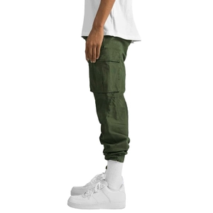 Détail d'un pantalon cargo vert armée avec poches latérales à rabat et bas élastique