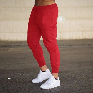 Detail view of red slim fit joggers featuring drawstring waist and ribbed cuffs