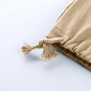 Détail d'un pantalon cargo kaki avec cordon de serrage tressé et finitions à franges