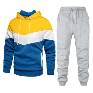 Detail of color-block hooded sweatshirt and gray drawstring joggers set on white background