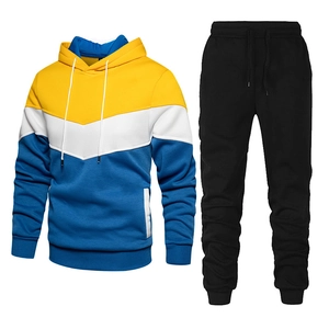 Close-up of men's tracksuit hoodie with yellow, white, and blue geometric patchwork design