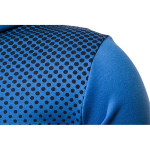Dettaglio del tessuto in maglia blu scuro con motivo a pois neri sulla zona della spalla