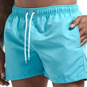 Detail showing elastic drawstring waistband and side pocket on blue quick-dry swim trunks