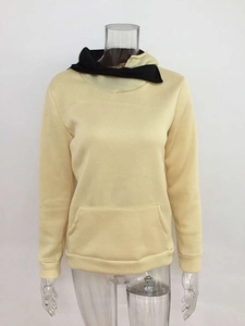 Detail view of beige pullover hoodie with black lapel collar and kangaroo pocket