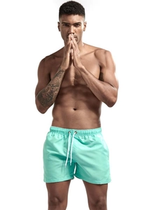 Close-up of mint green quick-dry swim trunks with elastic waistband and white drawstrings