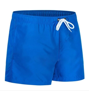 Detail of royal blue quick-dry swim trunks featuring elastic waist with white drawstrings