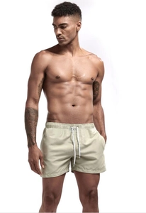 Detail of khaki quick-dry beach shorts featuring an elastic waist and white drawstring