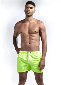 Detail of neon green quick-dry swim trunks with elastic waistband and white drawstrings