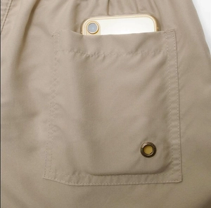 Detail of cargo pocket on quick-dry beach shorts showing durable fabric and metal eyelet