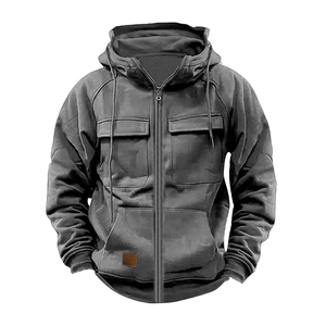 Detail of dark gray hooded workwear jacket with chest pockets and brown leather patch