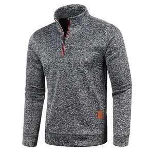 Detail of grey quarter-zip sweater with red contrast trim and leather hem label