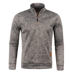 Detail view of men's quarter-zip sweater showing grey texture and leather hem label