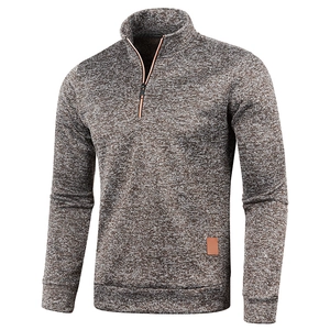 Close-up of men's quarter-zip knitted sweater with ribbed cuffs and leather label detail