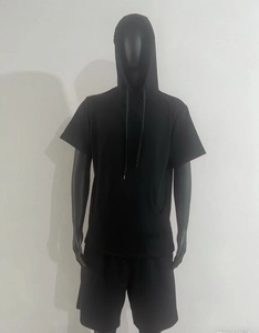 Détail d'un ensemble de sport noir à manches courtes avec capuche et poche kangourou