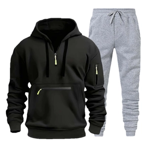 Dettaglio della felpa nera con mezza zip e tasche e dei pantaloni sportivi grigi