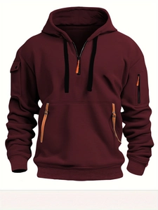 Detail of burgundy hoodie featuring a half-zip neckline and utility sleeve pocket