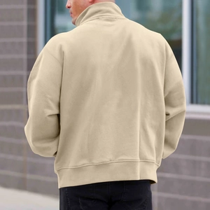 Back view of cream fleece sweatshirt featuring stand collar and ribbed hem outdoors