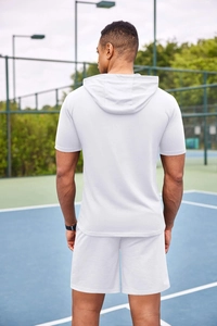 Ensemble short et sweat à capuche blanc pour homme sur fond de court de tennis