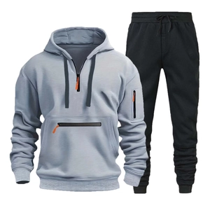 Dettaglio felpa con cappuccio celeste con zip arancione e pantaloni sportivi neri con coulisse