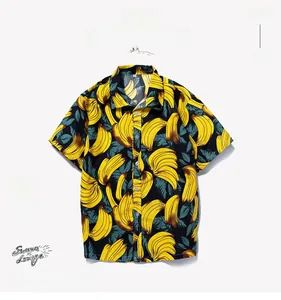 Detail of yellow banana print on a black Hawaiian shirt with soft shadows on white backdrop