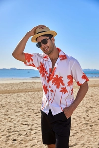 Detail of orange palm tree print on lightweight white fabric of a summer beach shirt