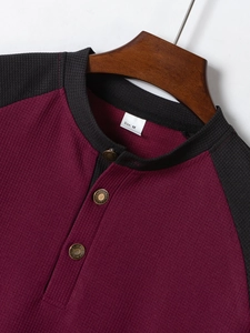 Dettaglio del tessuto a nido d'ape e dei bottoni in metallo sulla maglia Henley