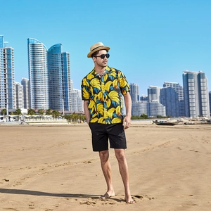 Men's bright yellow banana print Hawaiian beach shirt with casual black shorts