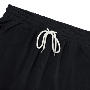 Detalle de pantalones de lino con cintura elástica y cordones blancos en contraste