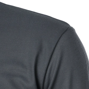Macro detail of the dark gray breathable mesh fabric shoulder seam on a polo shirt
