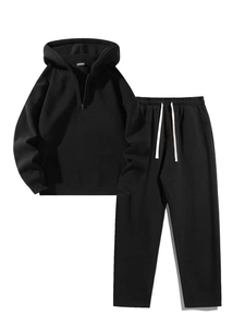 Detail view of black two-piece tracksuit with half-zip hoodie and elastic drawstring pants
