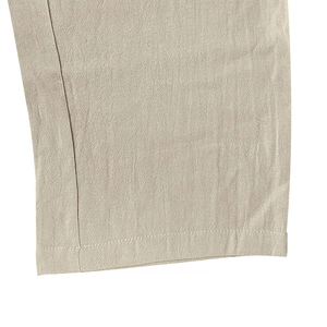 Primer plano detallado del dobladillo de doble costura en pantalones cargo de lino beige