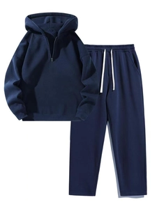 Detail view of navy blue half-zip hoodie and drawstring sweatpants set on white background