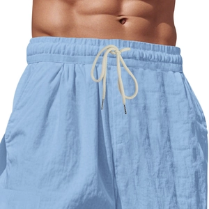 Detalle de los pantalones cortos de lino azul claro con cintura elástica y cordón crema