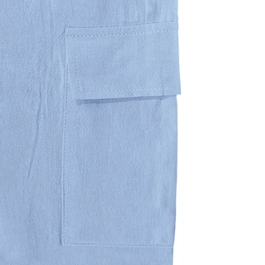 Primer plano de un bolsillo de lino azul claro con costuras limpias y textura de tela tejida