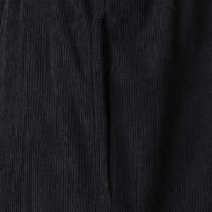 Macro view of deep black corduroy fabric texture and fine stitching on men's shorts