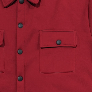 Détail de la veste tactique rouge foncé avec boutons-pression mats et poches cargo