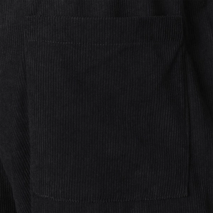 Close-up of black corduroy fabric texture and patch pocket detail on summer shorts