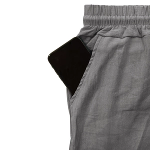 Detalle de pantalones cargo de lino gris que muestran el bolsillo lateral profundo funcional