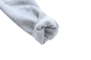 Close-up detail of light grey cotton hoodie showing warm fleece lining and ribbed cuffs