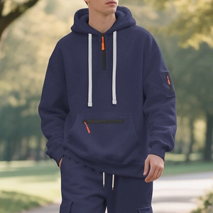 Detail of navy hoodie with orange zipper accents and cargo pockets in outdoor setting