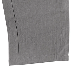 Detalle del pantalón de lino gris con textura de tela y costuras dobles reforzadas