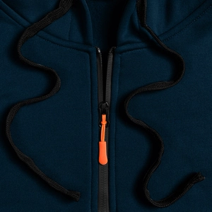 Dettaglio felpa blu navy con zip nera e tirante arancione su tessuto a maglia