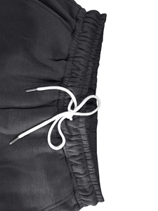Détail du jogging gris avec taille élastique froncée et cordons de serrage blancs