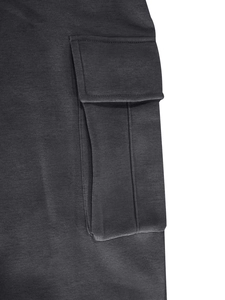 Détail macro de la poche cargo et des coutures sur un pantalon tactique en polaire
