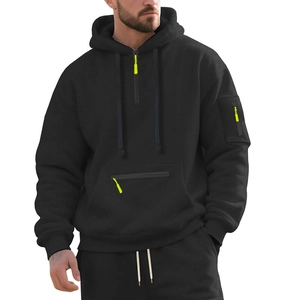 Detail view of black heavy hoodie showing fluorescent green zipper on arm sleeve and pocket