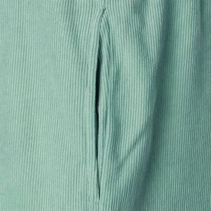 Close-up of mint green corduroy shorts showing textured fabric and side pocket detail