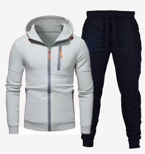 Detail von grauem Kapuzenpullover und marineblauer Jogginghose mit orangefarbenen Akzenten